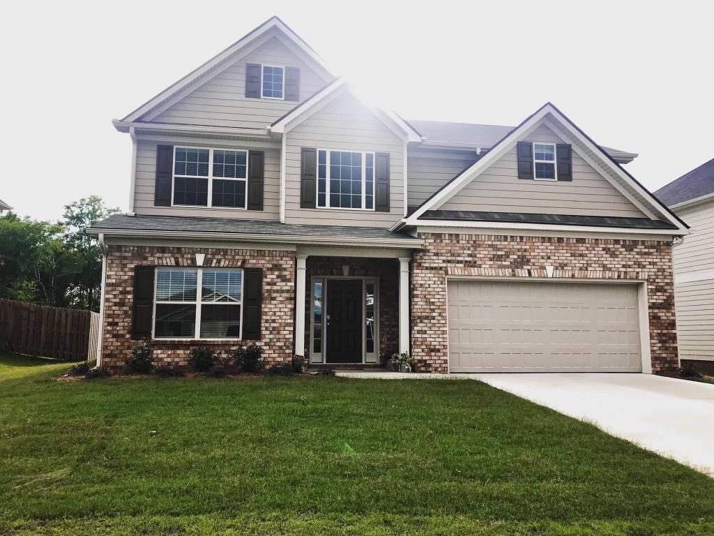 a front view of a house with a garden and plants