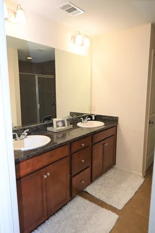 a spacious bathroom with a granite countertop sink and a mirror