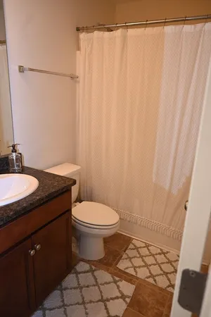 a bathroom with a granite countertop sink toilet and a mirror