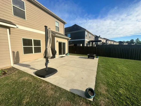 a view of a house with backyard and a tree