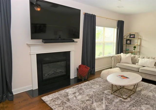 a living room with furniture a flat screen tv and a fireplace