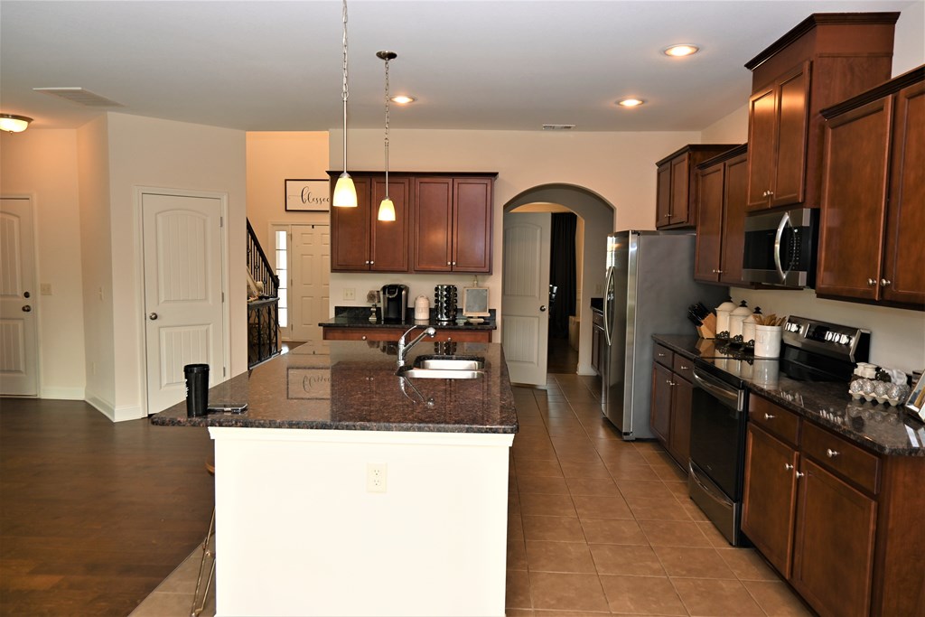 7279 Double Pine Drive Midland, GA 31820 - Photo 5 of 26 a kitchen with stainless steel appliances granite countertop a sink and a refrigerator