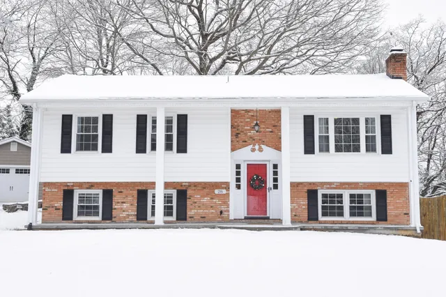 a front view of a building with large trees