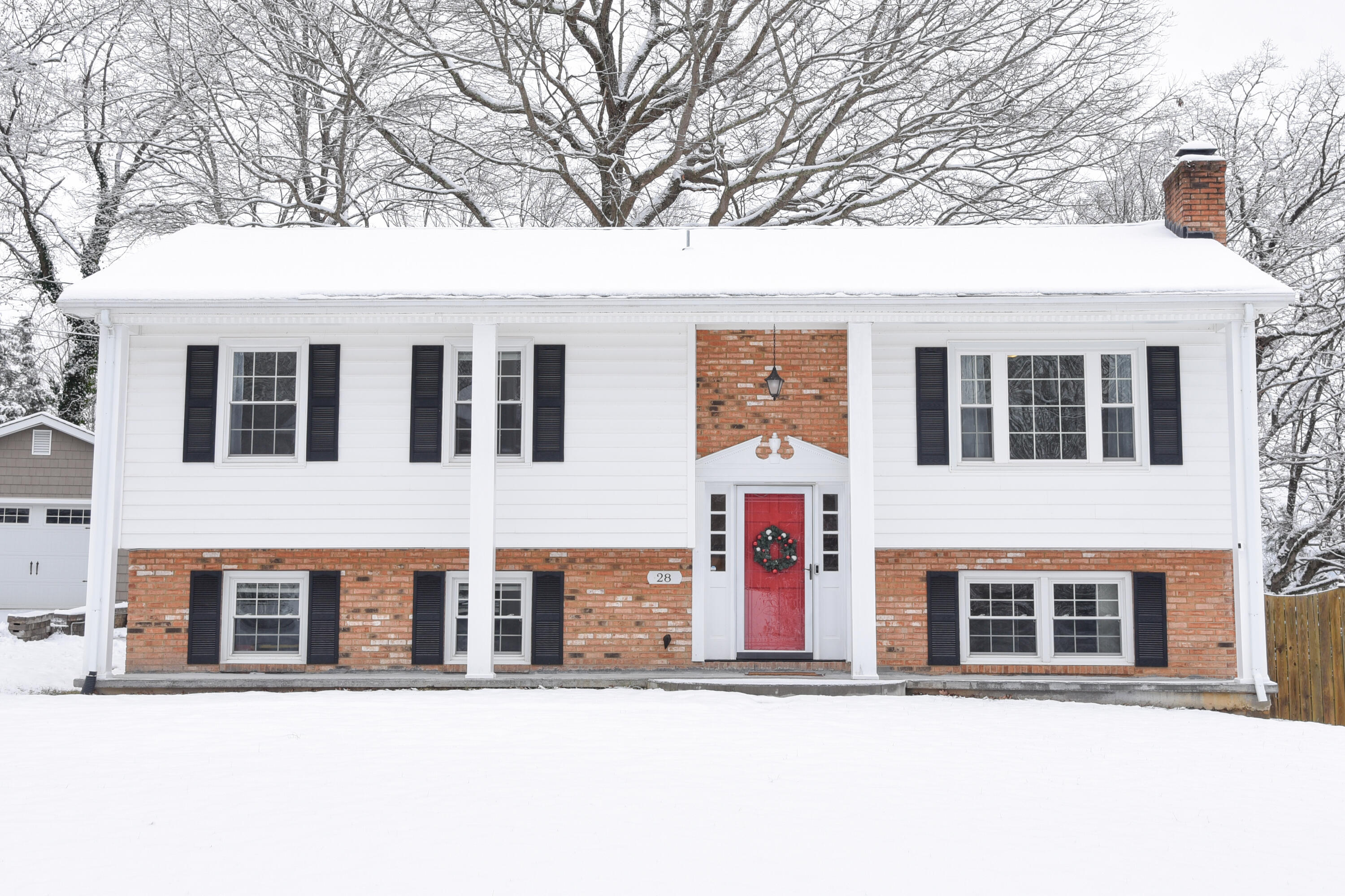 a front view of a building with large trees