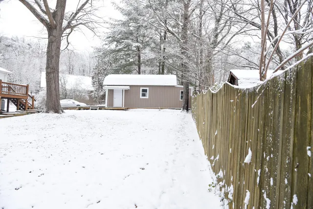 a front view of residential houses with yard and trees