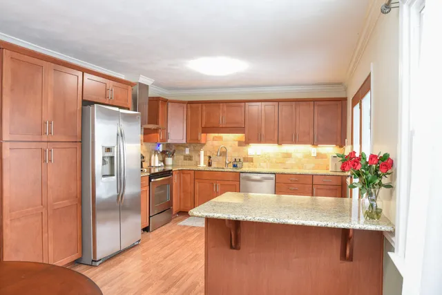 a kitchen with granite countertop a refrigerator and a sink
