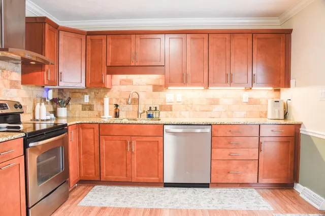a kitchen with granite countertop wooden cabinets a sink and dishwasher