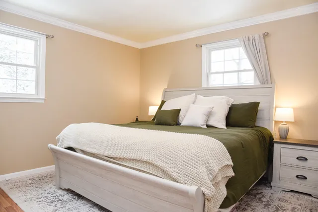 a bed sitting in a bedroom next to a window