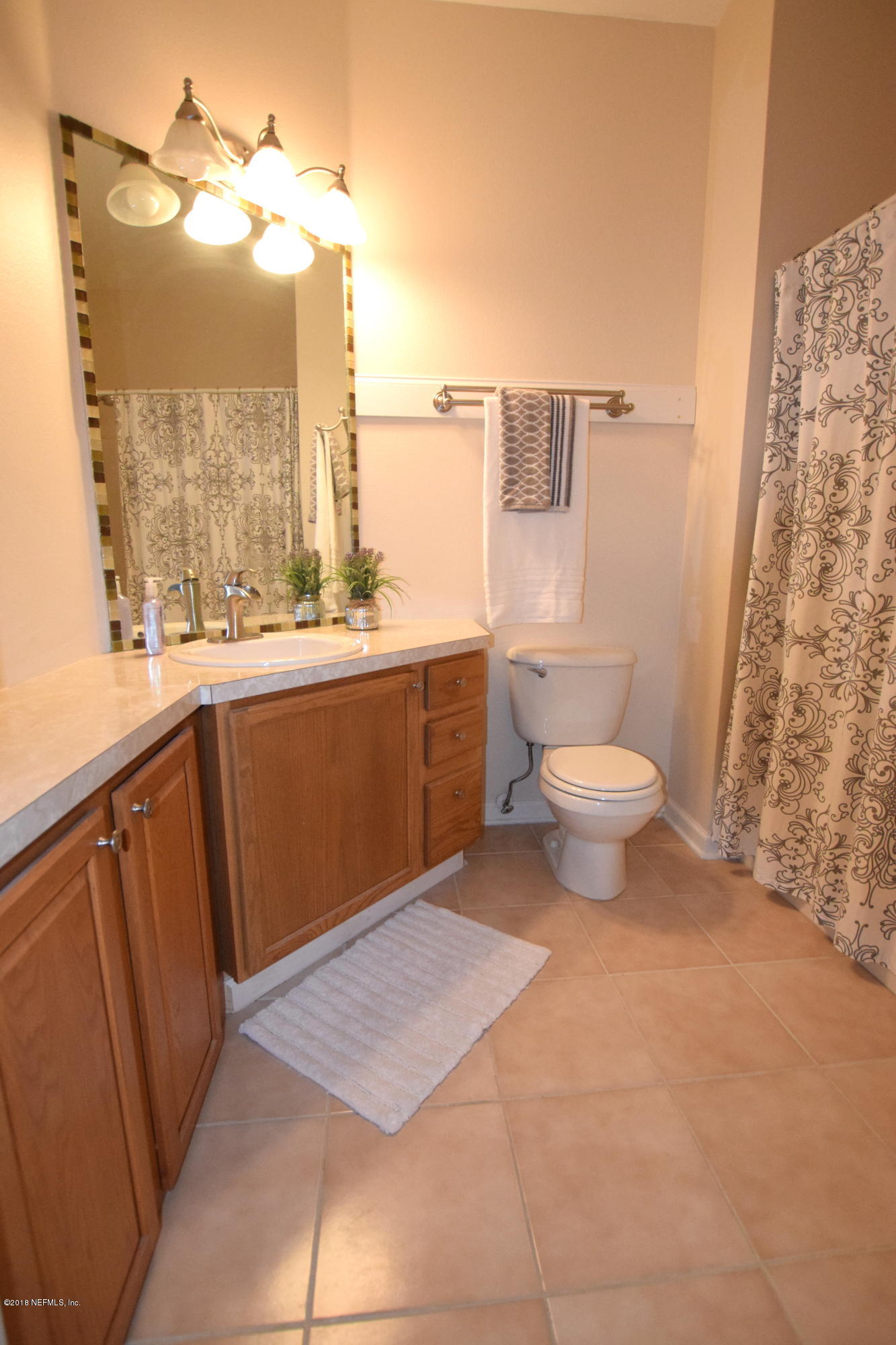 10550 Baymeadows Road, Unit 1016 Jacksonville, FL 32256 - Photo 10 of 17 a bathroom with a sink a toilet and a shower curtain