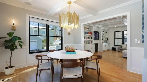 a dining room with furniture a rug and a potted plant
