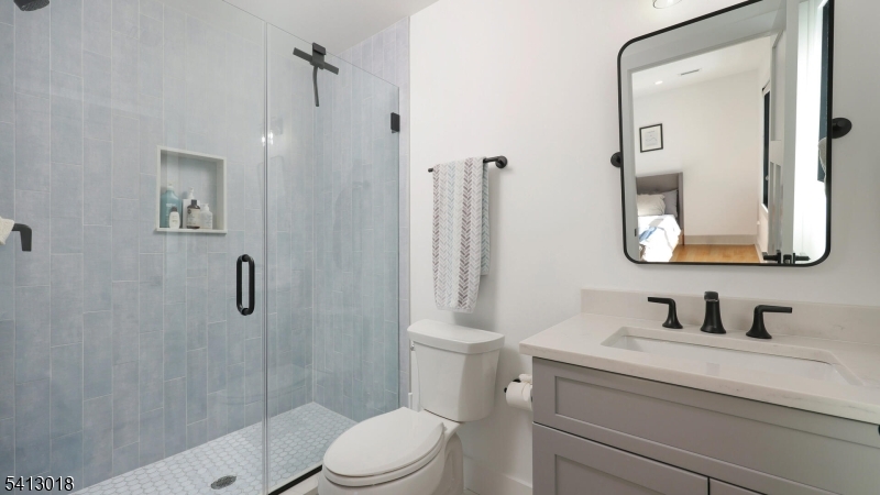 1613 Rising Way Westfield, NJ 07090 - Photo 39 of 50 a bathroom with a toilet a sink a glass door a shower and mirror