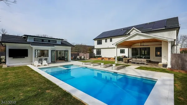 a view of a house with swimming pool and sitting area