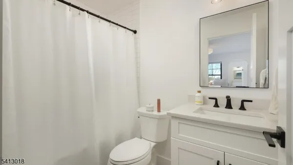 a bathroom with a granite countertop toilet sink and mirror