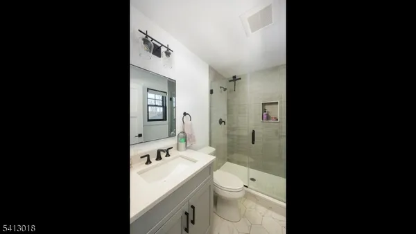 a spacious bathroom with a double vanity sink toilet mirror and bathtub