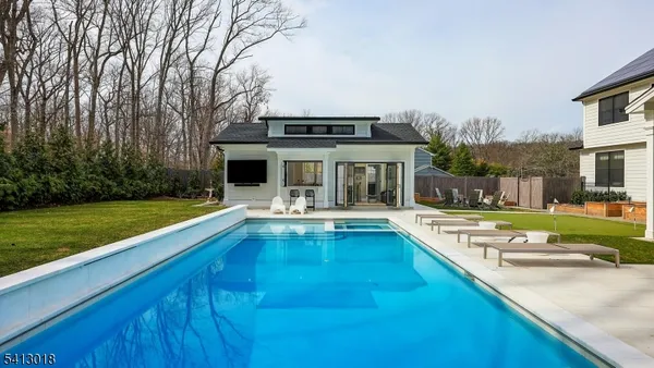 a view of house with swimming pool and yard