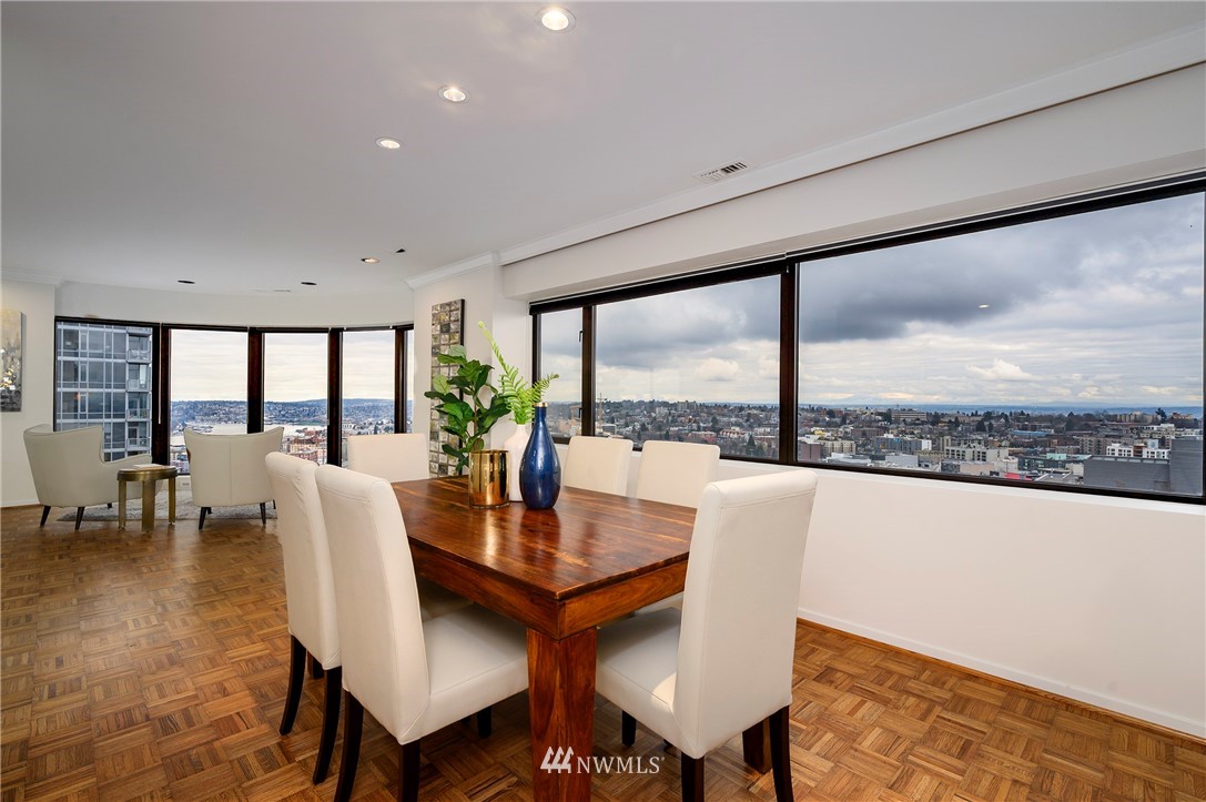 1301 Spring Street, Unit 20G Seattle, WA 98104 - Photo 2 of 24 a dining room with furniture a rug and a large window