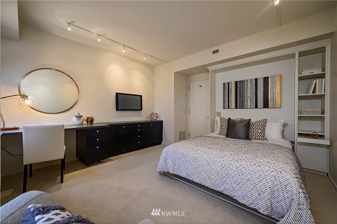 1301 Spring Street, Unit 20G Seattle, WA 98104 - Photo 10 of 24 a bedroom with a large bed and a flat screen tv