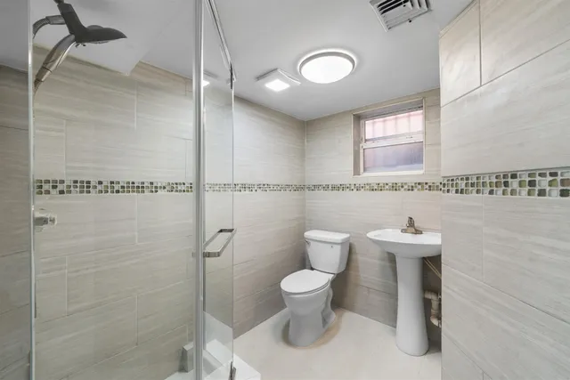 a bathroom with a toilet a sink and mirror