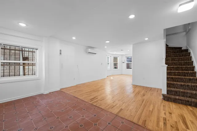 a view of empty room with wooden floor and windows