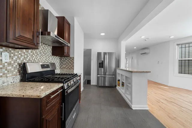 a kitchen with stainless steel appliances granite countertop a stove a sink and a refrigerator