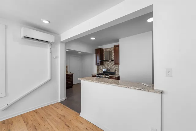 a kitchen with kitchen island a stove a refrigerator and a sink