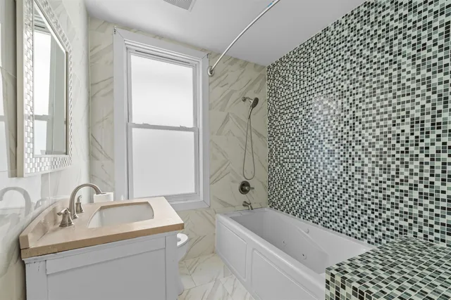 a bathroom with a bathtub sink vanity and toilet