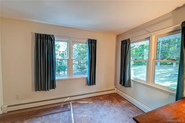 a bedroom with window and a dresser