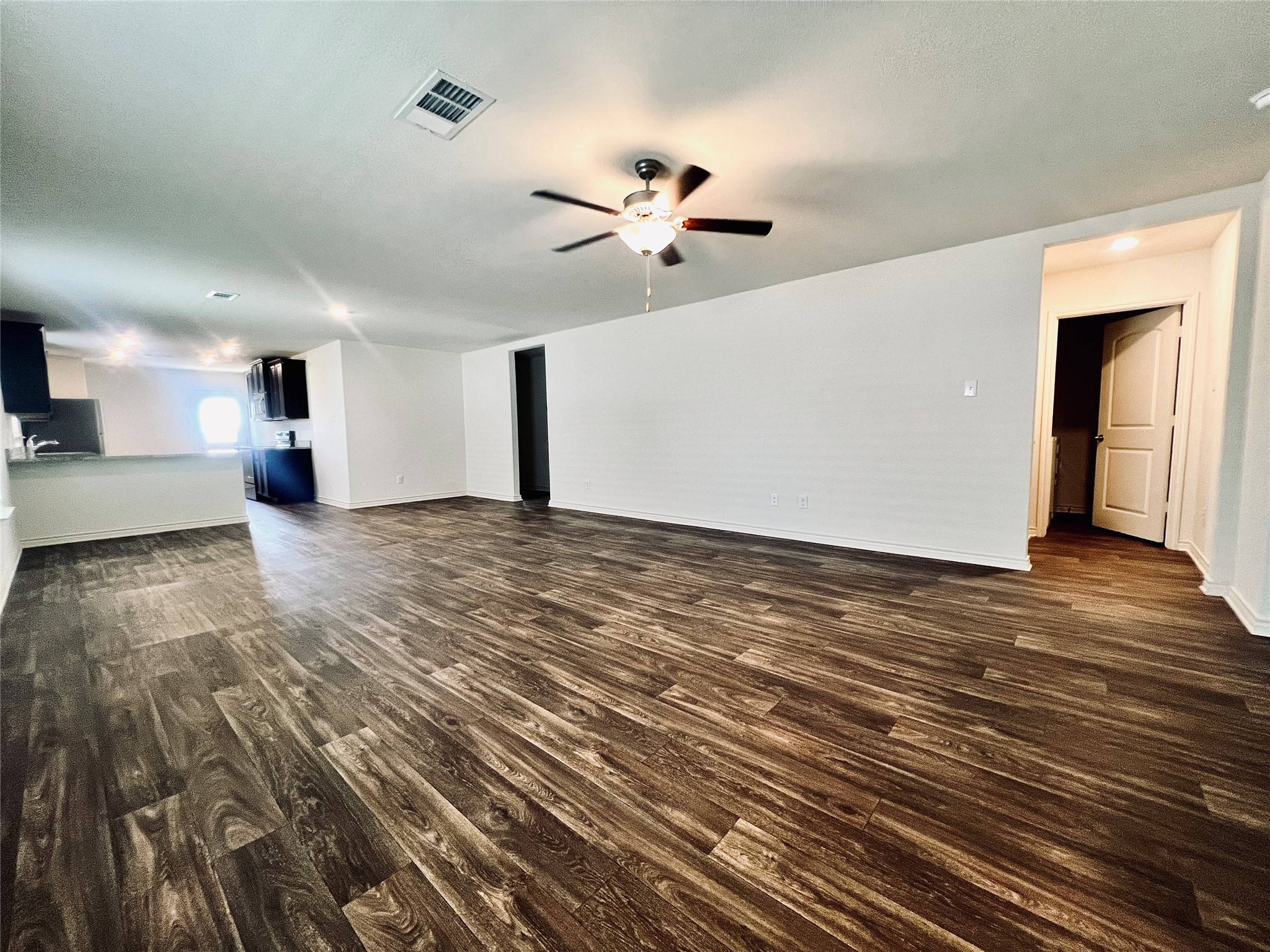 520 Locksley Cove Jarrell, TX 76537 - Photo 4 of 27 A spacious main living area features rich wood flooring and an inviting kitchen view.