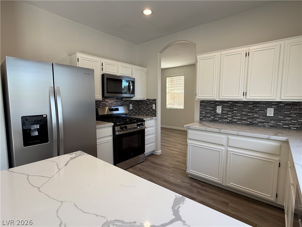 1908 Thunder Ridge Circle Henderson, NV 89012 - Photo 8 of 28 A contemporary kitchen features bright cabinetry, stainless appliances, and stylish patterned backsplash.