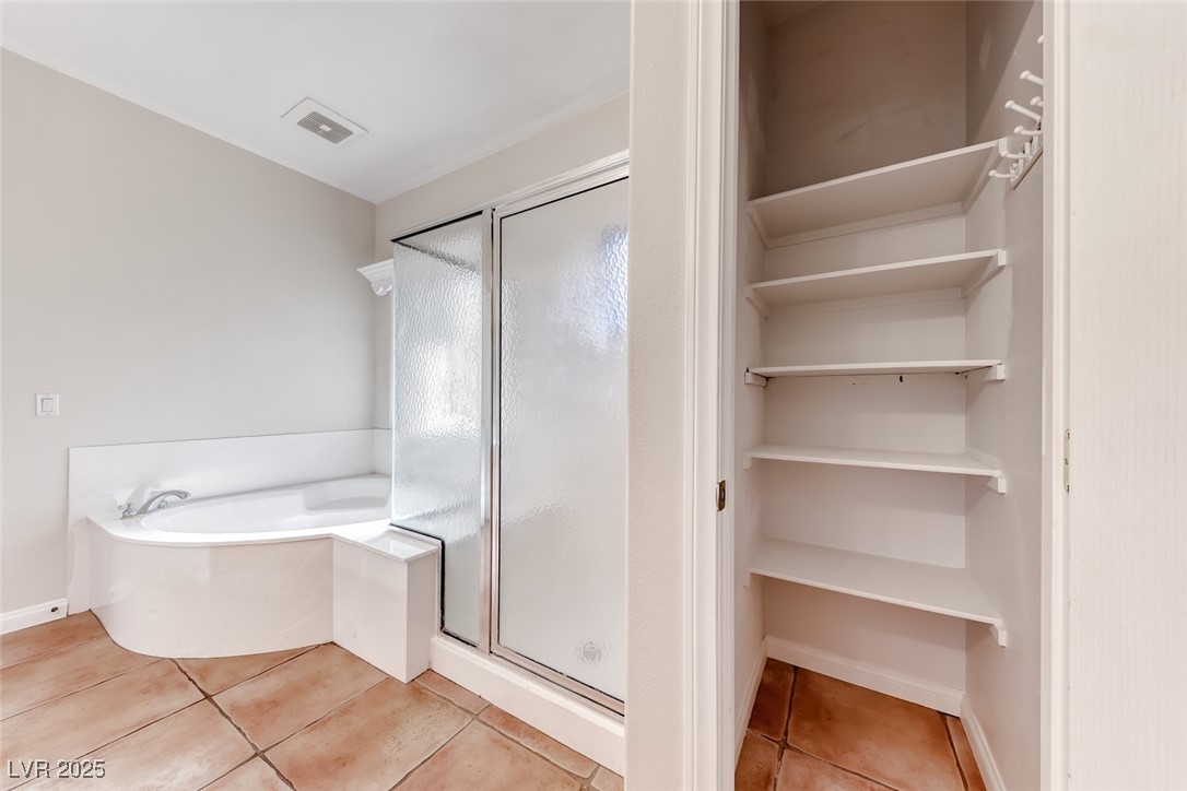 698 Magic Cove Court Boulder City, NV 89005 - Photo 14 of 41 Full bathroom featuring light tile patterned floors, a shower stall, and a bath