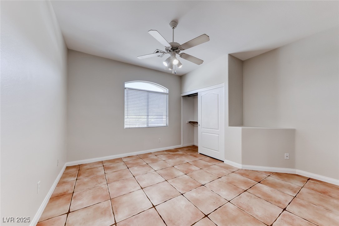 698 Magic Cove Court Boulder City, NV 89005 - Photo 20 of 41 Unfurnished bedroom featuring light tile patterned flooring, a closet, and a ceiling fan