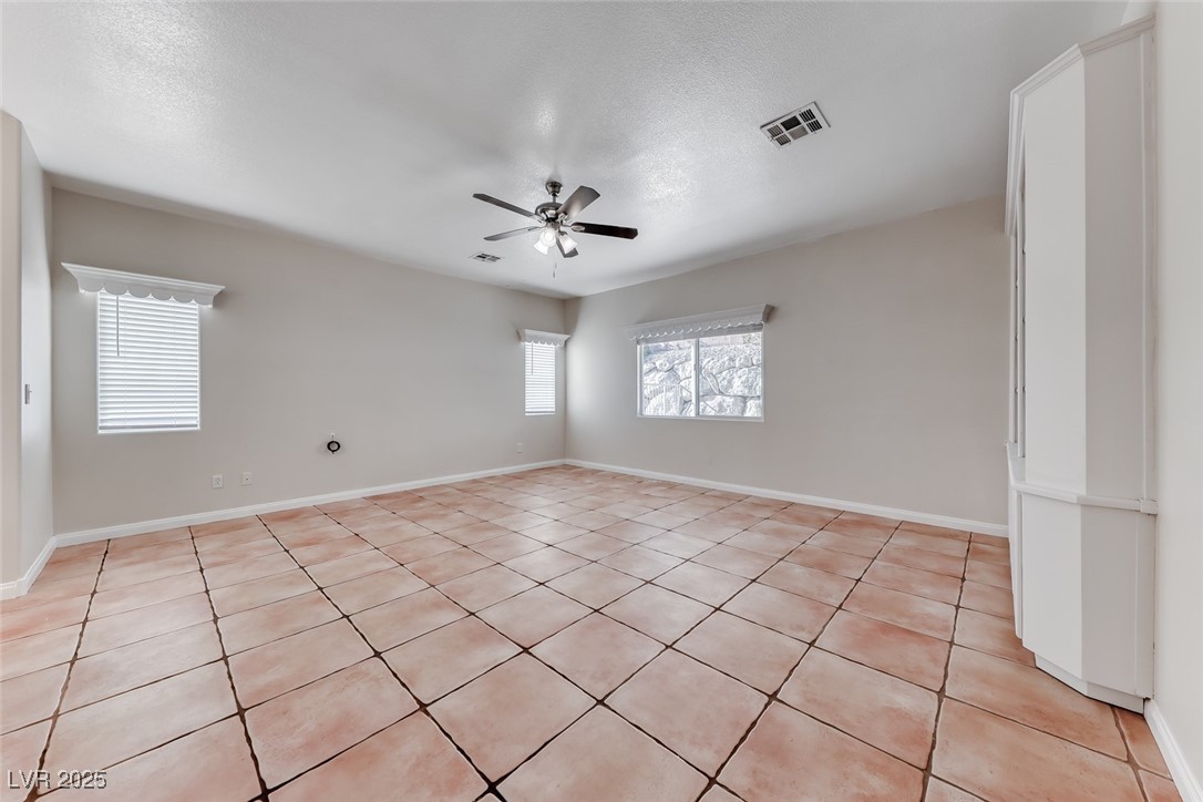 698 Magic Cove Court Boulder City, NV 89005 - Photo 26 of 41 Unfurnished room featuring light tile patterned floors, a ceiling fan, and a textured ceiling