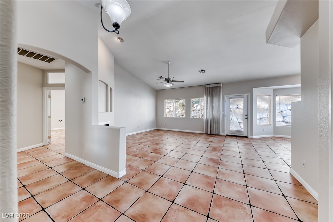 698 Magic Cove Court Boulder City, NV 89005 - Photo 37 of 41 Unfurnished living room featuring light tile patterned flooring, lofted ceiling, ceiling fan, and arched walkways