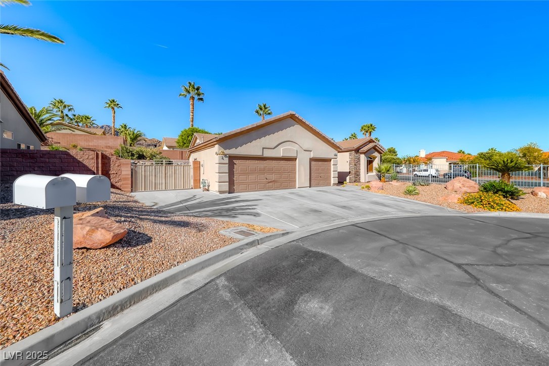 698 Magic Cove Court Boulder City, NV 89005 - Photo 39 of 41 View of front facade with concrete driveway, a gate, stucco siding, and an attached garage