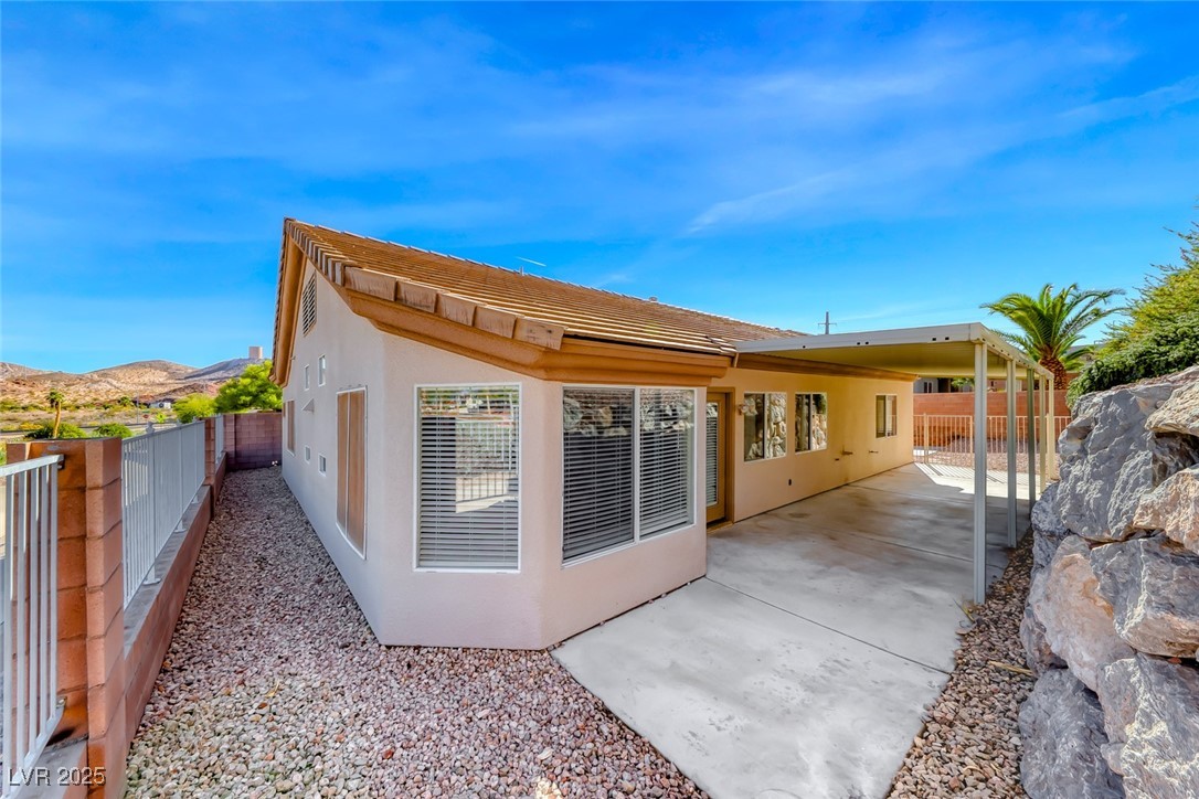 698 Magic Cove Court Boulder City, NV 89005 - Photo 6 of 41 Back of house with a fenced backyard, stucco siding, and a patio
