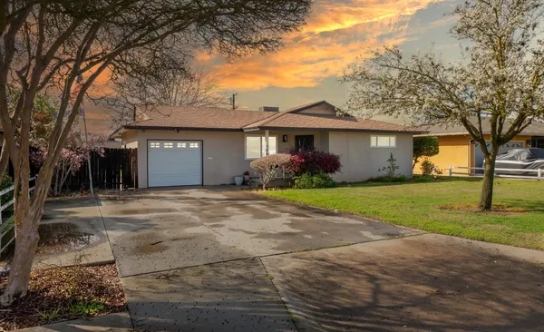 a front view of house with yard and trees around