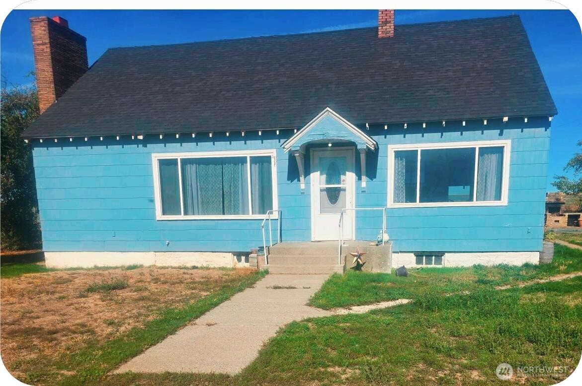 a front view of a house with a garden and yard