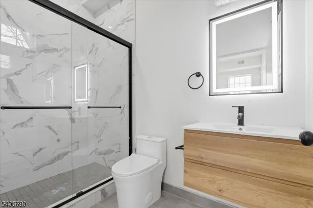 a bathroom with a toilet a sink and mirror