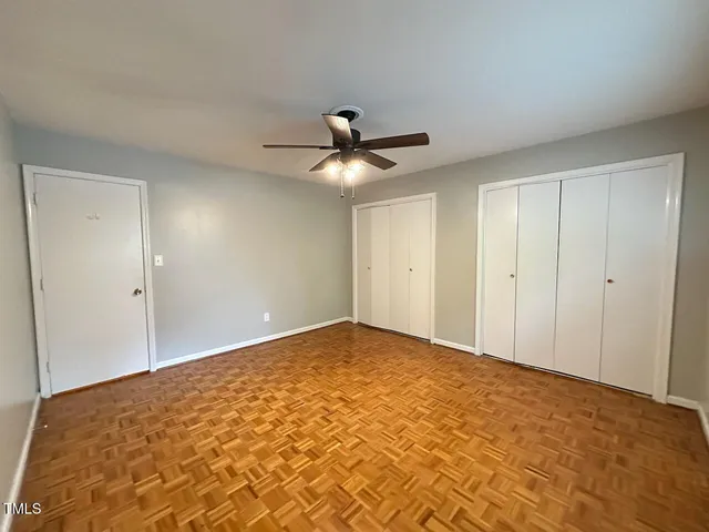 a view of an empty room and chandelier fan