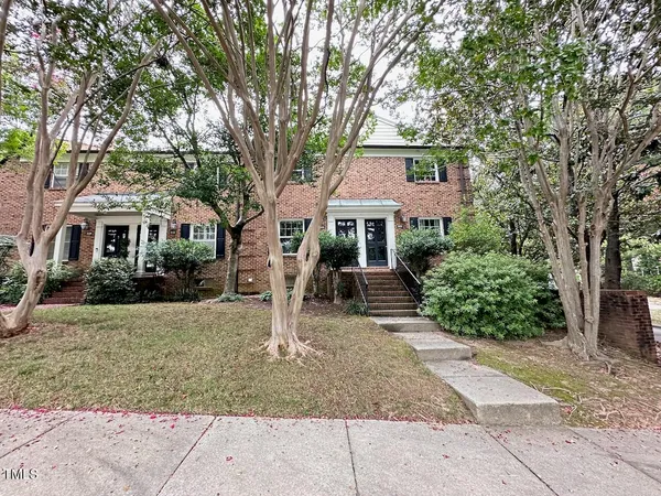 a front view of a house with a tree