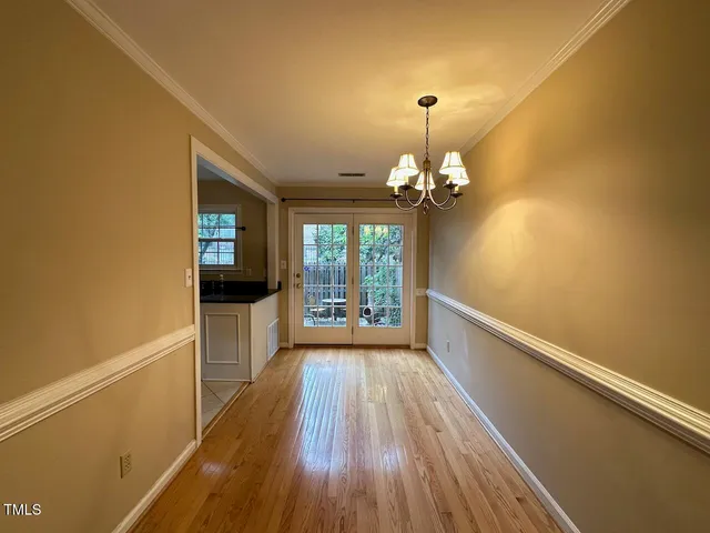 a view of a room with wooden floor fan and windows