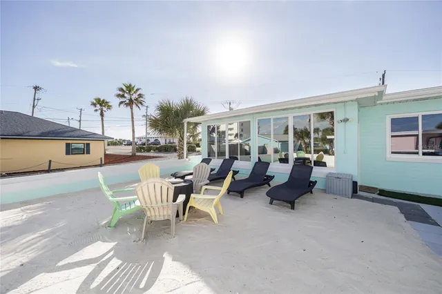 a front view of a house with a garden and chairs