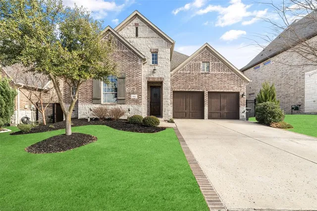 a front view of a house with a yard and trees