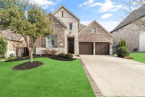 a front view of a house with a yard and trees