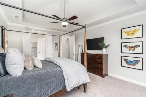 a bedroom with a large bed and a flat screen tv