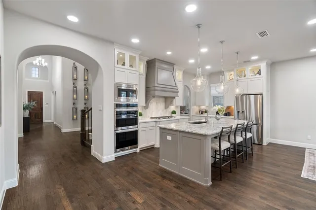 a kitchen with a sink and chairs
