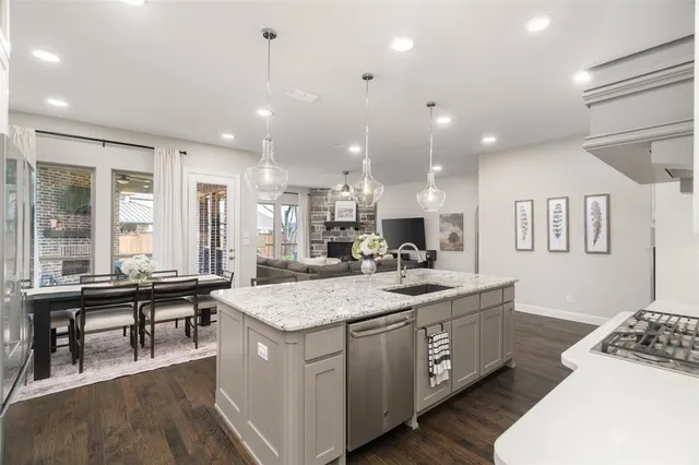 a large kitchen with kitchen island a sink a stove a dining table and chairs