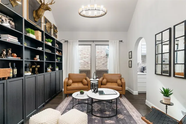 a living room with furniture a bookshelf and a potted plant