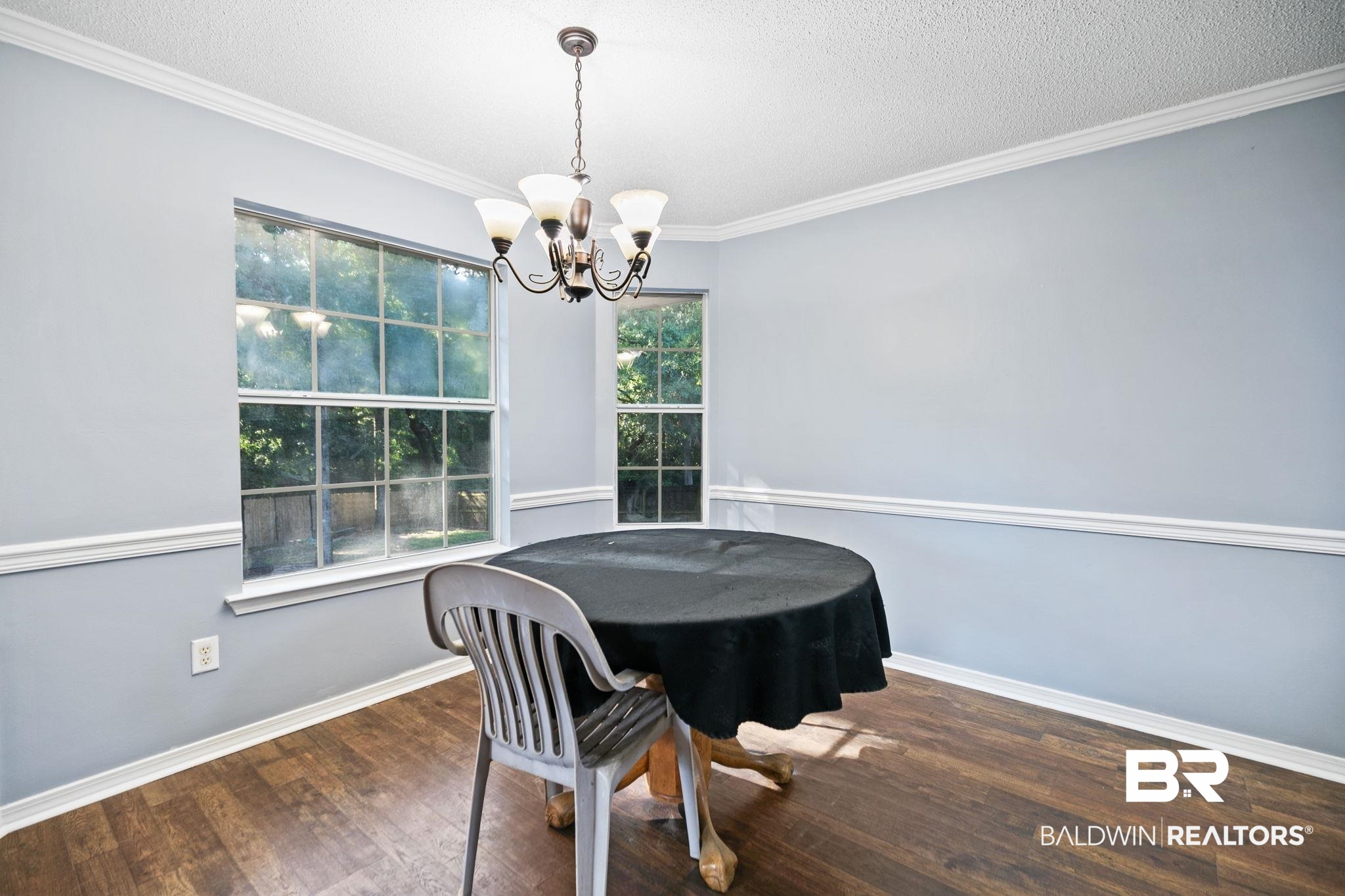 10550 Patrick Avenue Grand Bay, AL 36541 - Photo 21 of 43 Dining area with an inviting chandelier, dark wood-type flooring, a textured ceiling, and ornamental molding