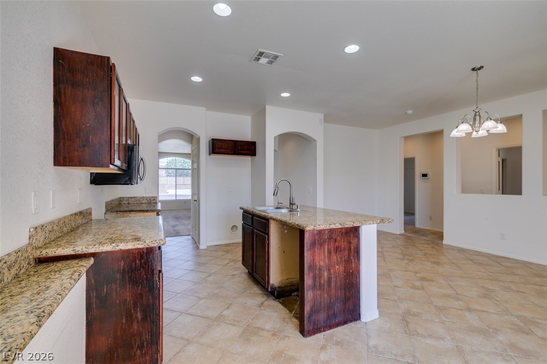 5150 Riverside Run Court North Las Vegas, NV 89081 - Photo 28 of 50 Granite counters and rich cabinetry define this practical kitchen, offering generous prep and storage space.